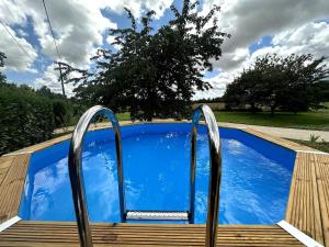 a plunge pool with a wooden deck and metal railings at Esprit Charentais - The Byre in Londigny