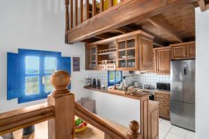a kitchen with wooden cabinets and blue accents at Villa Cleio where the sea meets absolute calm in Skiathos