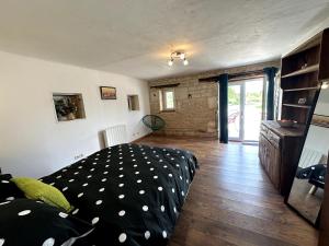 a living room with a black and white polka dot couch at Esprit Charentais - The Byre in Londigny