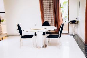 a white table and chairs in a room with a window at Stella nova motel in Kigali