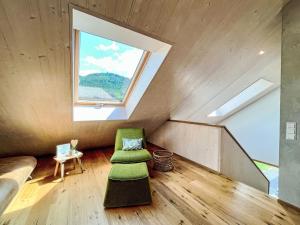 a room with a green chair and a window at Apartment Kinast - HFT202 by Interhome in Hofstetten