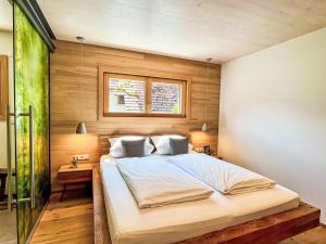 a bedroom with a large white bed with wooden walls at Apartment Kinast - HFT202 by Interhome in Hofstetten