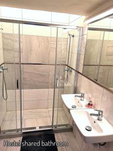 a bathroom with two sinks and a shower at Pension SKLEP in Prague