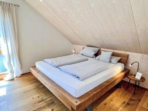 a bedroom with a wooden bed with white sheets at Apartment Kinast - HFT202 by Interhome in Hofstetten +77 photos