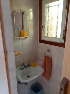 a small bathroom with a sink and a mirror at ELINOR-CASA PLAYERA - a 2 cuadras de la playa in Santa Clara del Mar +26 photos
