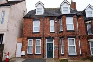 a red brick house with a green door at Seamflow Homes - Folkestone, near Eurotunnel - Channel Tunnel in Folkestone