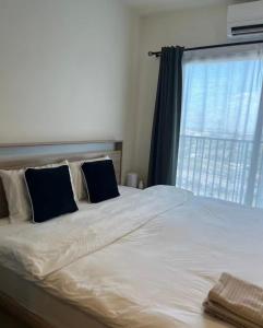 a bedroom with a large bed with a window at Mega Bangna Studio Retreat in Bang Kew Yai +21 photos