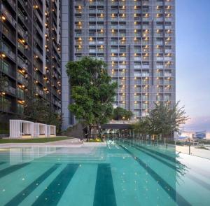an empty swimming pool in front of a tall building at Mega Bangna Studio Retreat in Bang Kew Yai