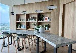 a kitchen with a large marble table and stools at Mega Bangna Studio Retreat in Bang Kew Yai