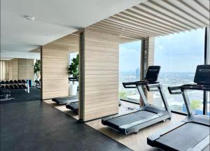 a gym with a row of treadmills and cardio machines at Mega Bangna Studio Retreat in Bang Kew Yai