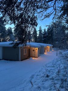 a row of buildings in the snow at night at Arctic Circle Holiday Homes in Rovaniemi