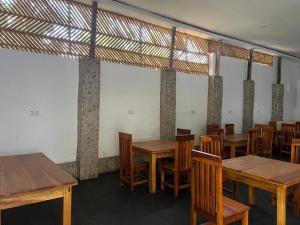 a dining room with wooden tables and chairs at The Paradise Inn Kilimanjaro in Moshi