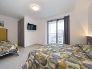a bedroom with a bed and a large window at Apartment Nashira-5 by Interhome in Lignano Sabbiadoro