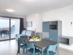 a kitchen and living room with a table and chairs at Apartment Nashira-5 by Interhome in Lignano Sabbiadoro