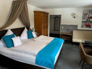 a bedroom with a bed with blue sheets and a desk at Schlosshotel Landstuhl in Landstuhl +36 photos