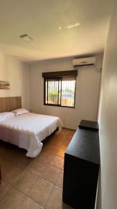 a bedroom with a bed and a window at Mare Mansa Residence in Florianópolis