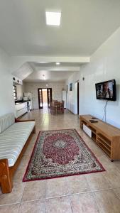a living room with a couch and a rug on the floor at Mare Mansa Residence in Florianópolis