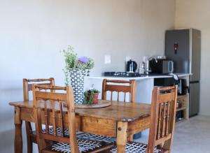 a wooden table with four chairs and a kitchen at Rietfontein 1888 in De Aar +16 photos