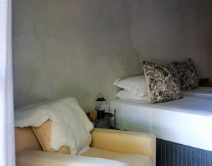 a bedroom with a bed and a couch and a chair at Rietfontein 1888 in De Aar