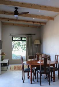 a dining room with a wooden table and chairs at Rietfontein 1888 in De Aar
