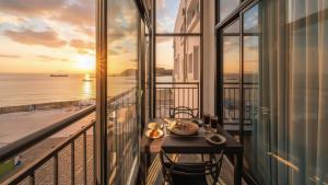 a table with food on a balcony with a view of the ocean at Yeosu Arungeorida Ocean View Pension in Yeosu