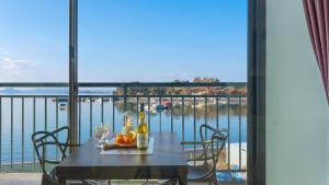 a table with bottles and glasses on a balcony with a view of the water at Yeosu Arungeorida Ocean View Pension in Yeosu