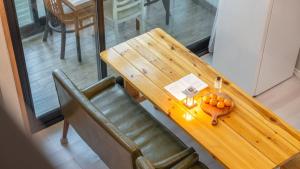 a wooden table and a chair with oranges on it at Yeosu Arungeorida Ocean View Pension in Yeosu +4 photos