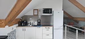 a kitchen with a white refrigerator and a microwave at Chez Jo et Mel - Gite et Yourtes in Bannost