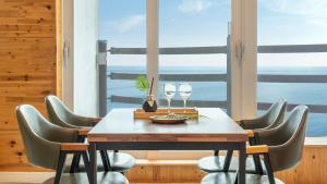 a dining room with a table and chairs and a window at Geoje Inbito Pension in Op'o