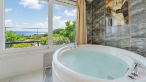 a bath tub in a bathroom with a window at Yangyang Monti Pet Spa Pension in Yangyang +12 photos