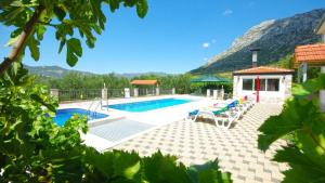a swimming pool with chairs and a mountain in the background at Vila Nova with private heating pool and jacuzzi in Zavojane