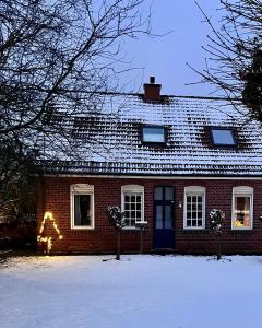 a red brick house with a christmas tree in the window at Ferienhaus nahe Münster in Altenberge