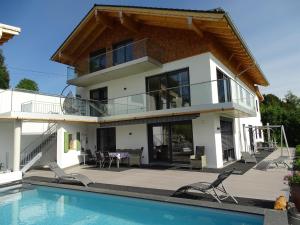 a villa with a swimming pool and a house at Ferienwohnung Horizont in Ofterschwang