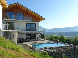 a house with a swimming pool in front of it at Ferienwohnung Horizont in Ofterschwang