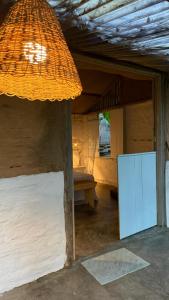 a room with a white refrigerator and a table at Pouso do Cajueiro - Moreré in Cairu