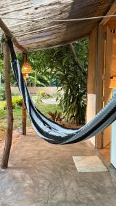 a black hammock hanging under a porch at Pouso do Cajueiro - Moreré in Cairu +26 photos