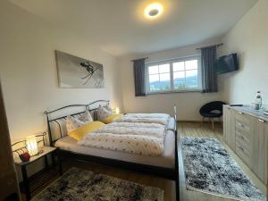 a bedroom with a bed with yellow pillows and a window at Ferienwohnung Horizont in Ofterschwang +27 photos
