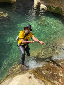 a man is standing in the water holding a fishing pole at Wadi hawer tour guiding and local farm tour in Biḑ‘ah