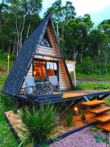 a small cabin with a pitched roof and a deck at Chale Pepê in Campo Alegre