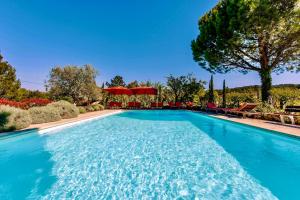 a swimming pool with blue water in a yard at Bastide Saint-Didier in Saint-Didier