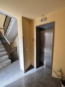 a hallway with a metal door and stairs at Teatro Massimo - Apartment with a View of Theater Massimo in Palermo