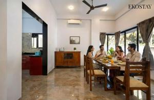 a group of people sitting around a dining room table at EKOSTAY - Mercury Villa in Alibaug