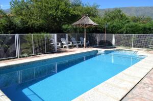 a swimming pool with a fence around it at Cabañas Quilquelen in Merlo