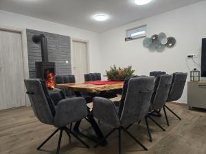 ein Esszimmer mit Tisch und Stühlen sowie einem Kamin in der Unterkunft Blidinje S7 - Risovac -280 m staza in Jablanica
