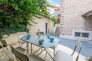 a patio with a table and chairs on a balcony at Happyfew maison Michelet in Nice