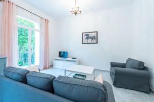 a living room with a couch and a chair and a table at Happyfew maison Michelet in Nice