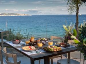 a table with plates of food on top of the ocean at Ionian Hill Hotel in Argassi