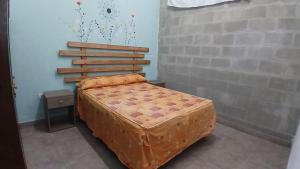 a bed in a room with a brick wall at La Casita de Junín in Junín