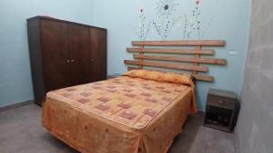 a bedroom with a large bed and a wooden headboard at La Casita de Junín in Junín
