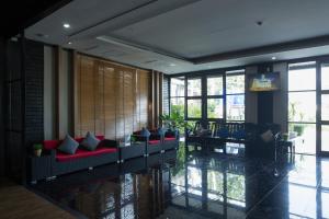 vestíbulo con sofás, mesa y ventanas en Golden Tulip Essential Pattaya en Pattaya North